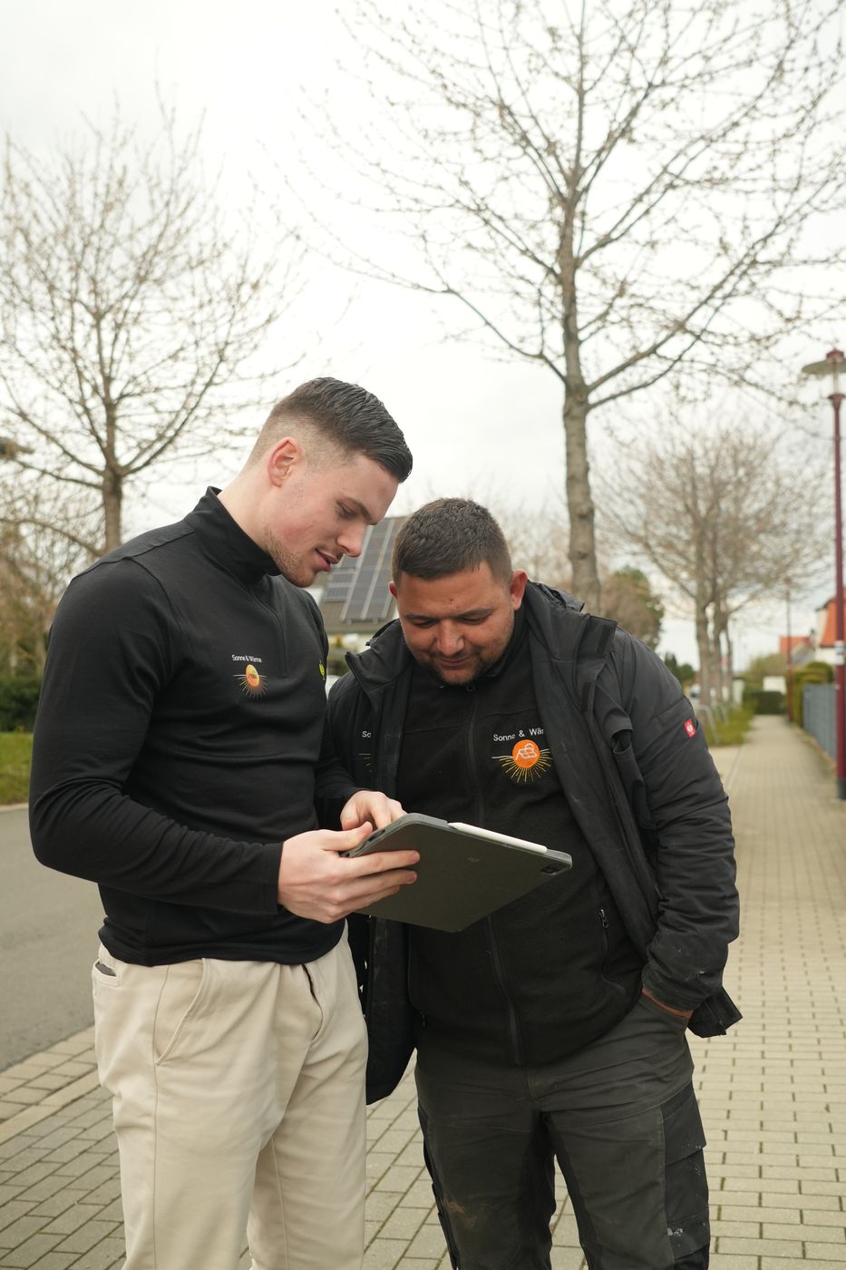 Berater zeigt einem Kollegen Unterlagen auf dem Tablet