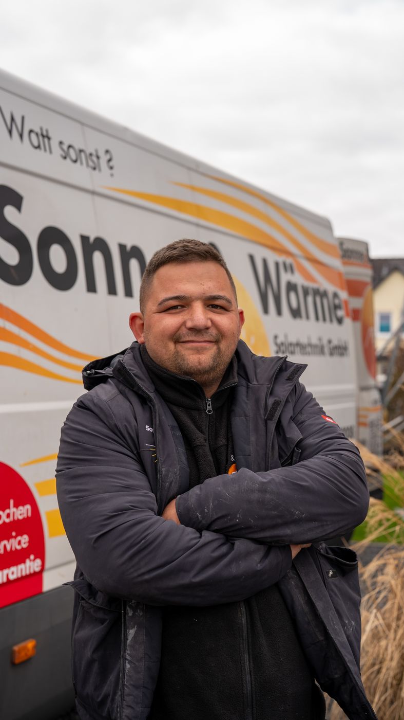 Monteur von Sonne & Wärme vor dem Firmentransporter